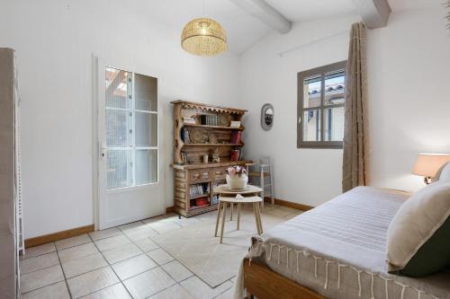 a bedroom with a bed and a table and a window at Le Mas de la Rode in Saumane