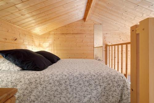 a bedroom with a bed in a wooden cabin at Chalet En Périgord Vert in Sainte-Croix-de-Mareuil
