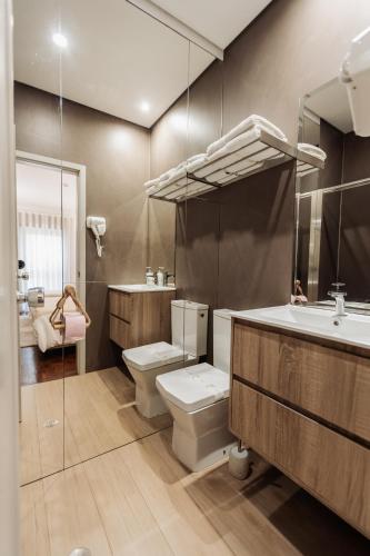 a bathroom with a toilet and a sink and a mirror at Vistas da Villa in Cabeceiras de Basto