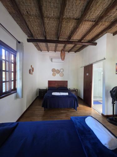 a bedroom with a bed and a wooden ceiling at Pousada da Praia in Paraty