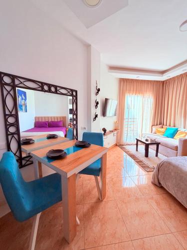 a living room with a wooden table and blue chairs at Jasmine Resort & Aqua park in Sharm El Sheikh