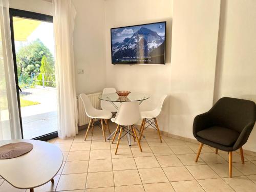 a living room with a table and chairs and a tv at SUNNY 2, Two-bedroom house with parking in Komotini