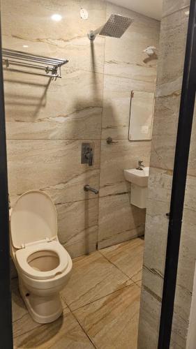 a bathroom with a toilet and a sink at Ira Wanderlust Homes & Tours in Trichūr