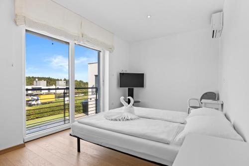 a white bedroom with a bed and a large window at Villa del Mar in Pula