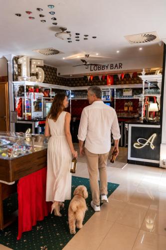 Ein Mann und eine Frau stehen mit einem Hund in einem Laden. in der Unterkunft Hotel Tommy Wellness & Spa in Náchod