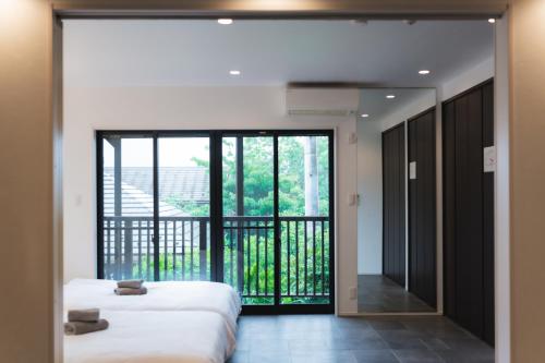 two beds in a room with a balcony at SANMI Hayama in Hayama