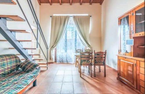 a living room with a table and chairs and a staircase at Casale Ciricó tra Catania e Siracusa in Carlentini