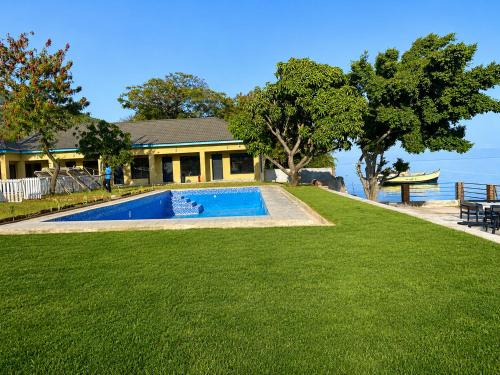 a house with a swimming pool next to the water at Summerland Lodge in Chembe