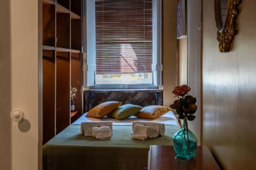 a room with a bed with pillows and a window at Dejavu Terrace Setúbal in Setúbal