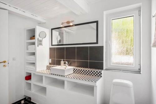 a white bathroom with a sink and a window at SJ342-Vamdrup-Holtvej-11-sommerhus in Vamdrup