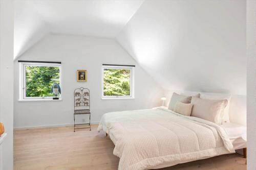 a white bedroom with a bed and two windows at SJ342-Vamdrup-Holtvej-11-sommerhus in Vamdrup