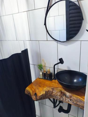 a bathroom with a black sink and a mirror at Chalé Romântico Privativo com Lareira e vista para Montanhas in Capela do Alto