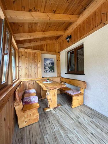 a wooden room with a table and benches in a cabin at Bungalows Ivan in Žabljak