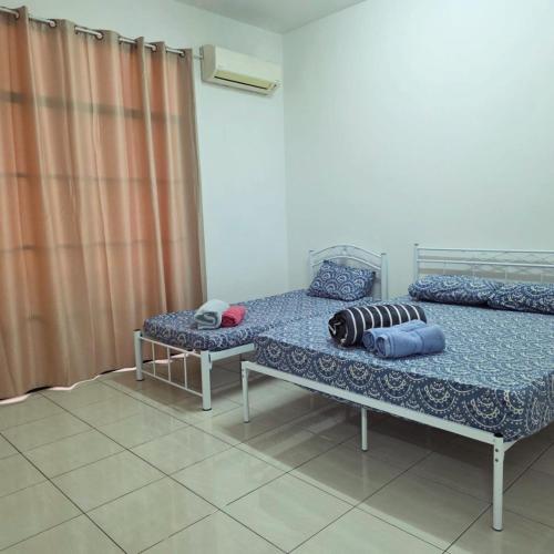 a bedroom with two beds and a curtain at Osvy Palm Homestay in Penampang