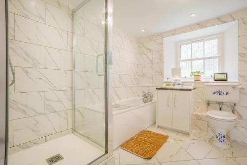 a white bathroom with a shower and a toilet at 3 Bed in Lintrathen oc-w42585 in Bridgend of Lintrathen