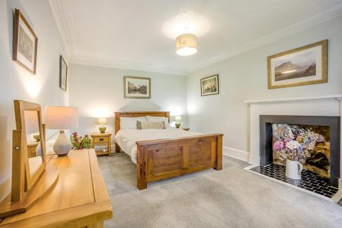 a bedroom with a bed and a fireplace at 3 Bed in Lintrathen oc-w42585 in Bridgend of Lintrathen