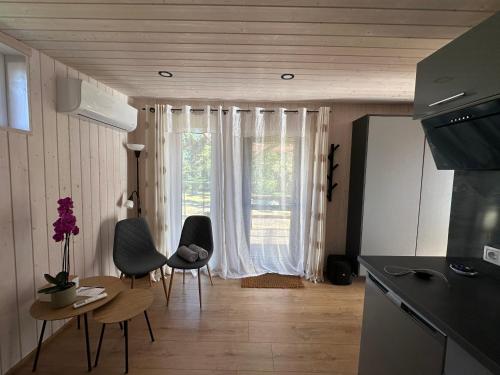 a kitchen with chairs and a table and a window at Dimantu nami in Upesgrīva