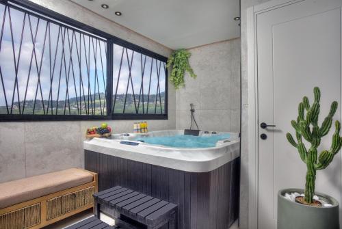 a bathroom with a tub with a cactus in it at דיאמנט - Diamond in Safed