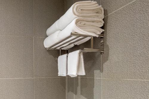 a group of white towels on a rack in a bathroom at Acoz in Ban Zong Katiam
