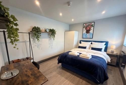 a bedroom with a blue bed and a table at Spacious one bedroom flat- super fast Wifi - slp4 -SHIP02 in Brighton & Hove