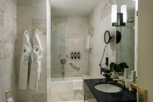 a bathroom with a sink and a shower and a tub at Altis Avenida Hotel, a member of Preferred Hotels & Resorts in Lisbon