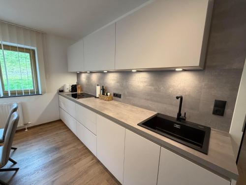 a kitchen with white cabinets and a sink at Mountain hOMES in Axams