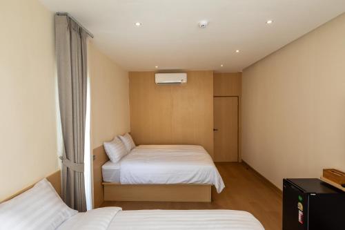 a bedroom with two beds and a window at Acoz in Ban Zong Katiam