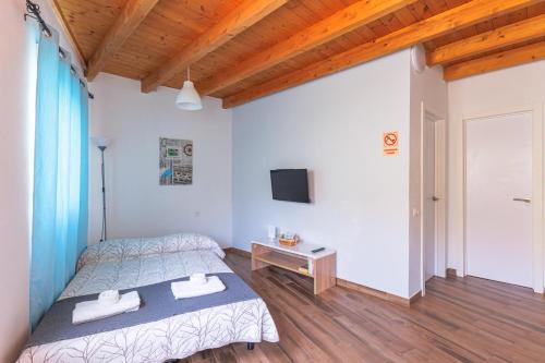 a bedroom with a bed and a table and a tv at Blue Río Playa, Casa & Studio in Costa Calma