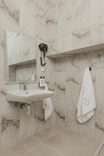 a white bathroom with a sink and a mirror at Papi Boutique Hotel in Vathí