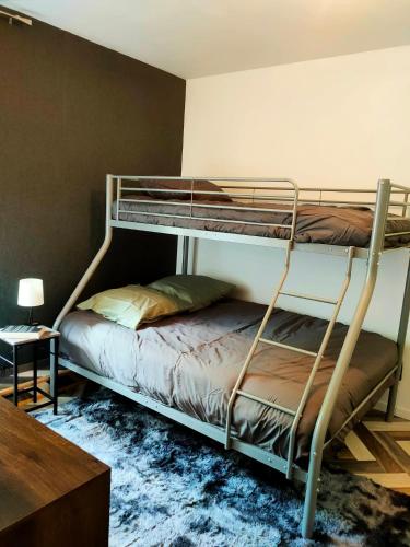 a bedroom with two bunk beds and a table at La Maison bleue in Rossillon
