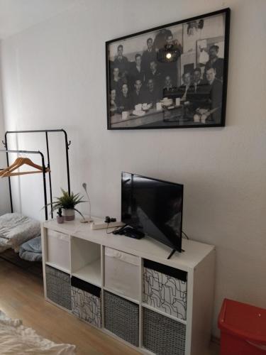 a living room with a television on a white cabinet at Cosy Studio flat in the centre of Colditz in Colditz