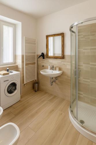 a bathroom with a sink and a washing machine at borgo nel vigneto 2 in Erbusco