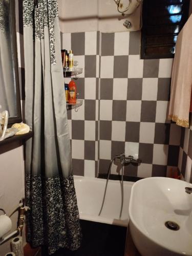 a bathroom with a checkered shower curtain and a sink at Marilyn's house in Amarynthos