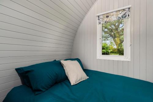 a blue couch in a room with a window at The Hideaway - Tranquil Glamping Pod in Narberth