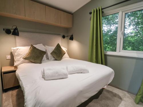 a large white bed in a room with a window at The Pines 2 Bedrooms in Northwich