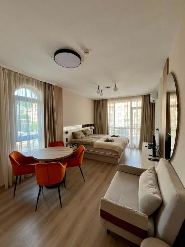 a living room with a bed and a table and chairs at Sorrento Pool View Apartment in Sveti Vlas