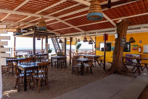 a restaurant on the beach with tables and chairs at Pousada La Bella Luna in Porto De Galinhas