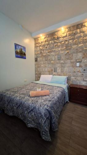 a bedroom with a bed with a stone wall at Casa Scalesia Apartments Galápagos in Puerto Baquerizo Moreno