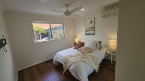 a bedroom with a bed with white sheets and a window at Seffa 5 vella property in Springvale South