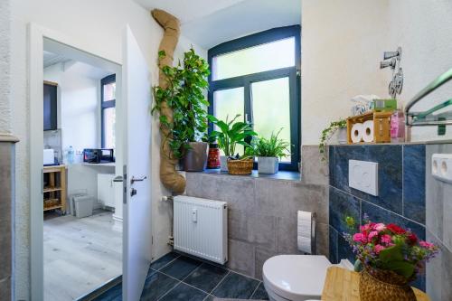 a bathroom with a toilet and plants on the wall at Pfarrgarten in Kippenheim