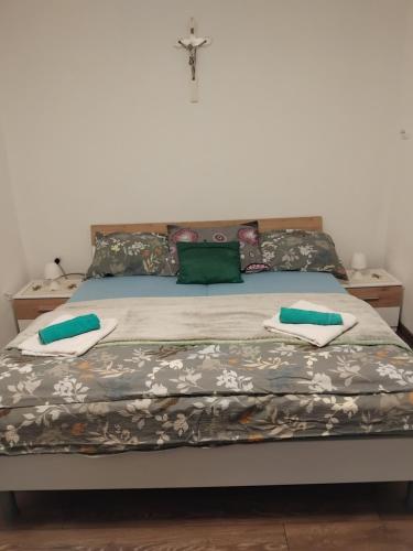 a bedroom with a bed with a cross on the wall at Nensi1 in Križišće