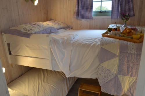a bedroom with a bed with a tray of fruit on it at 2 - Daisy in Woodbridge