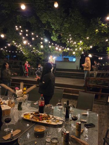 a table with a plate of food on it with people in the background at Pensiune Excelenta in Vermeşti