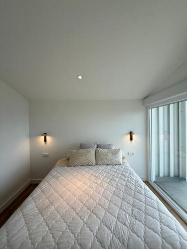 a bedroom with a large bed with a large window at Casa Broullón in Moaña