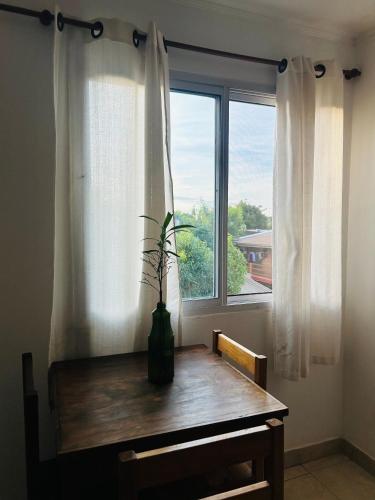 a table in front of a window with a plant on it at Departamento Centrico Iguazu 2B in Puerto Iguazú