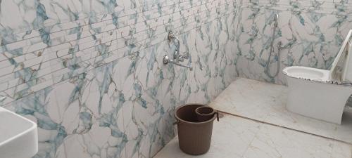 a bathroom with a toilet and a trash can at New Vivaantaa Hotel in Aurangabad