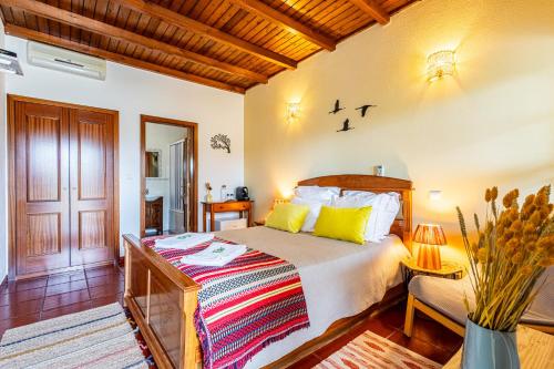 a bedroom with a bed with yellow pillows at Monte Além Tejo in Arraiolos