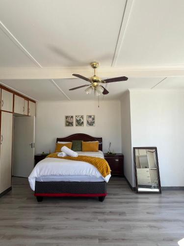 a bedroom with a bed and a ceiling fan at Sunrise Villa Self Catering and Accommodation in Lüderitz