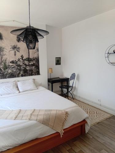 a bedroom with a large white bed with a chandelier at Le Tilleul du Perche - Jardin clos - Fibre - Télétravail - Parking privé in La Ventrouze