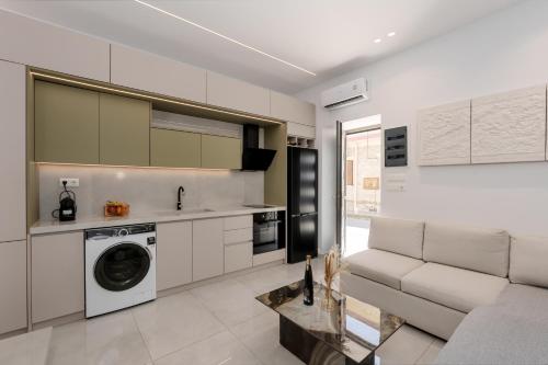 a kitchen with a washing machine and a couch at The Luxe Residence in episkopi-chania